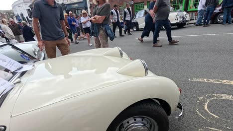 coches antiguos exhibidos en una calle concurrida