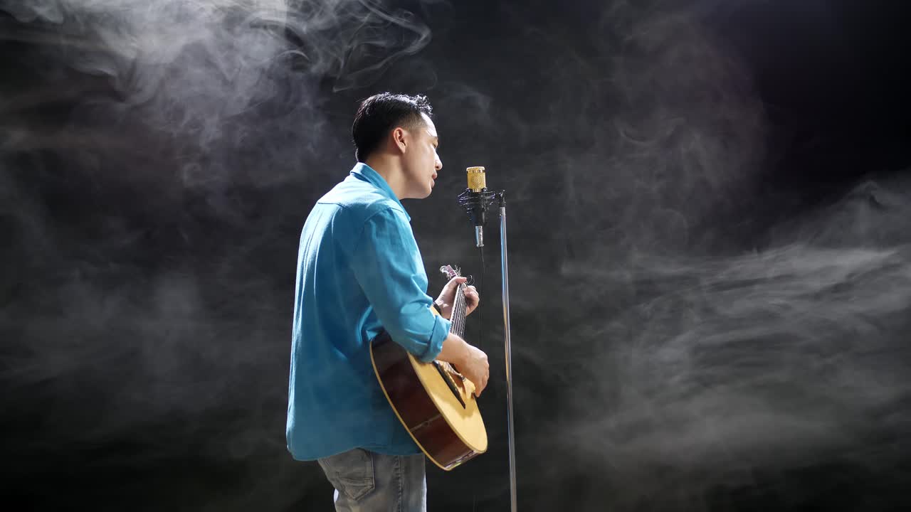 노래 하고 어쿠스틱 기타를 연주 하는 남자