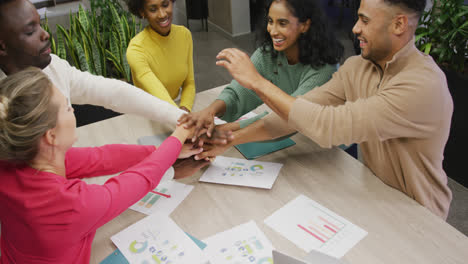 Happy-diverse-male-and-female-business-colleagues-teaming-up-in-office