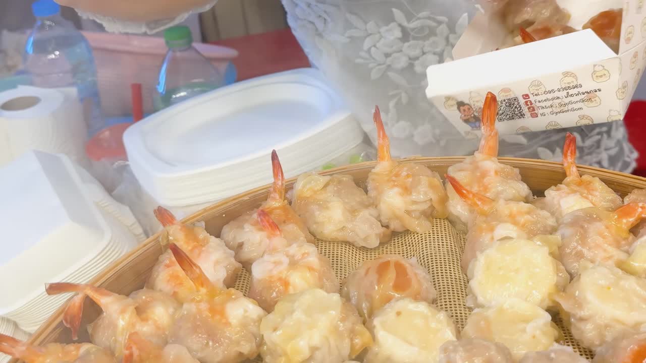 Vendor prepares steamed prawn and pork snacks