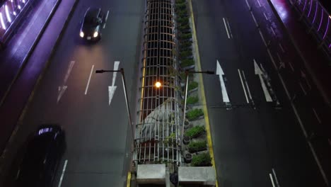 drone footage of a bridge at night lit with purple lights