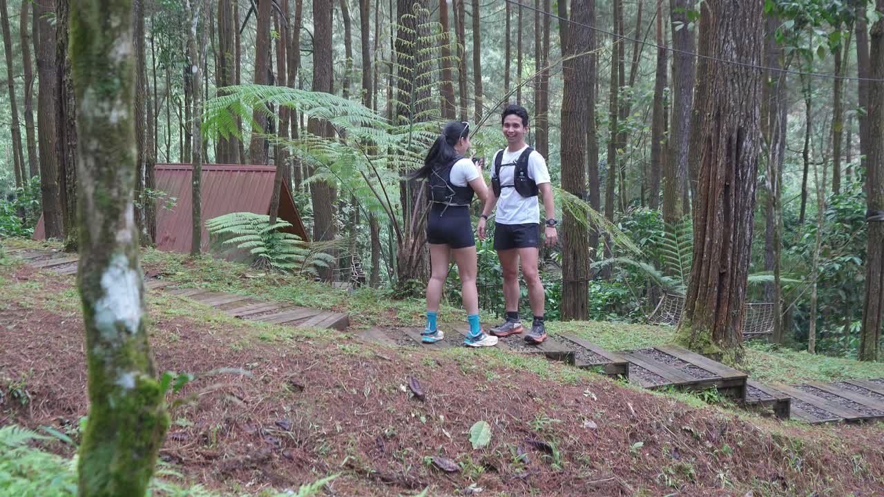 Indonesian young adults using smartphone during trail run in forest
