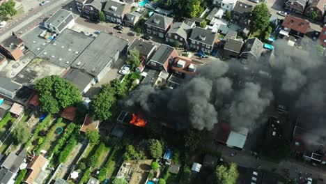 Aerial-shot-of-a-fire-burning-in-a-Dutch-shed-located-in-a-neighbourhood