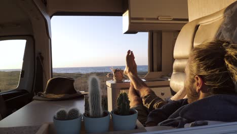 man travelling by camper van enjoying stunning sea side views from his vehicle.