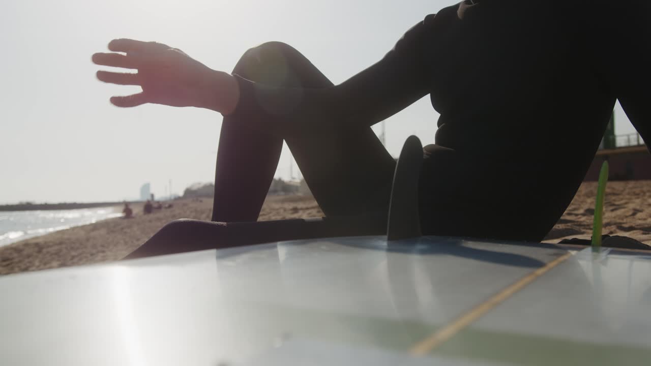 Surfer man walking to the beach at sunset preparing for surfing training and search for waves in Barcelona, spain, water, ocean exercise in sea with board, athletic male holiday or travel in vacation