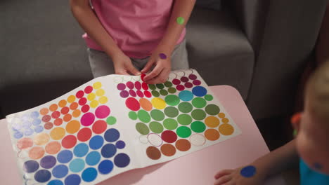 los niños juegan con pegatinas en círculos y las pegan una encima de la otra
