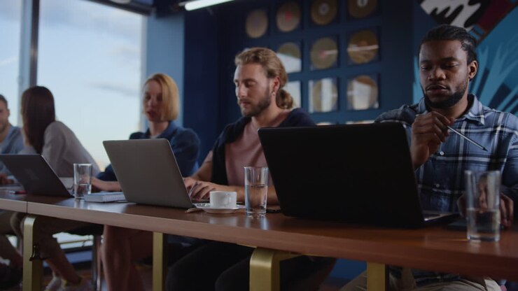 Multi-etnische zakenmensen werken laptopcomputers op de werkplek in coworking