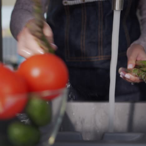 Woman-washes-asparagus