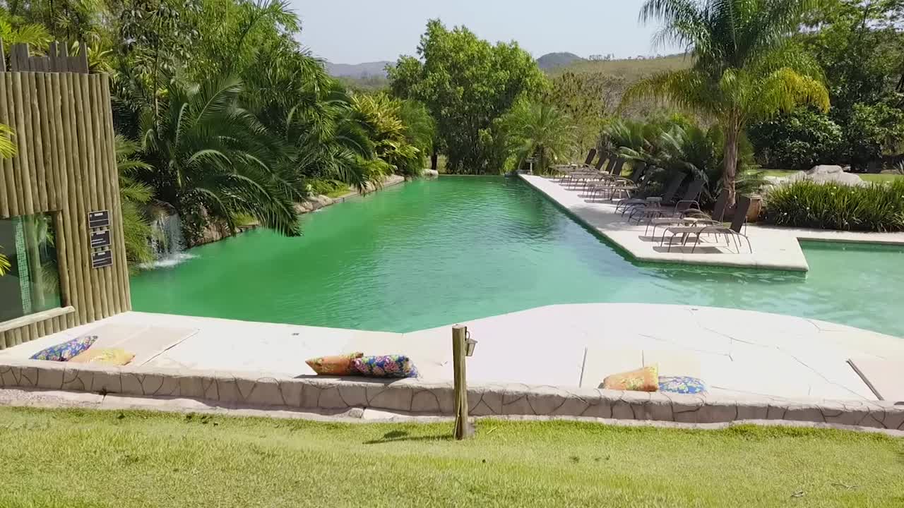 Reading a book by the pool. Drone shot over the gazebo.