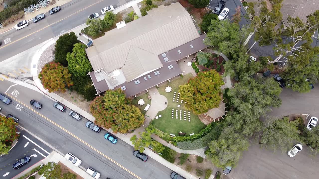 Top Down Aerial view of an outdoor wedding celebration setup with white chairs on a green lawn, in Rancho Santa Fe, California