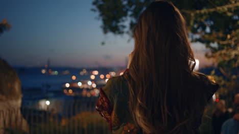 woman filming night cityscape on smartphone standing observation deck close up.