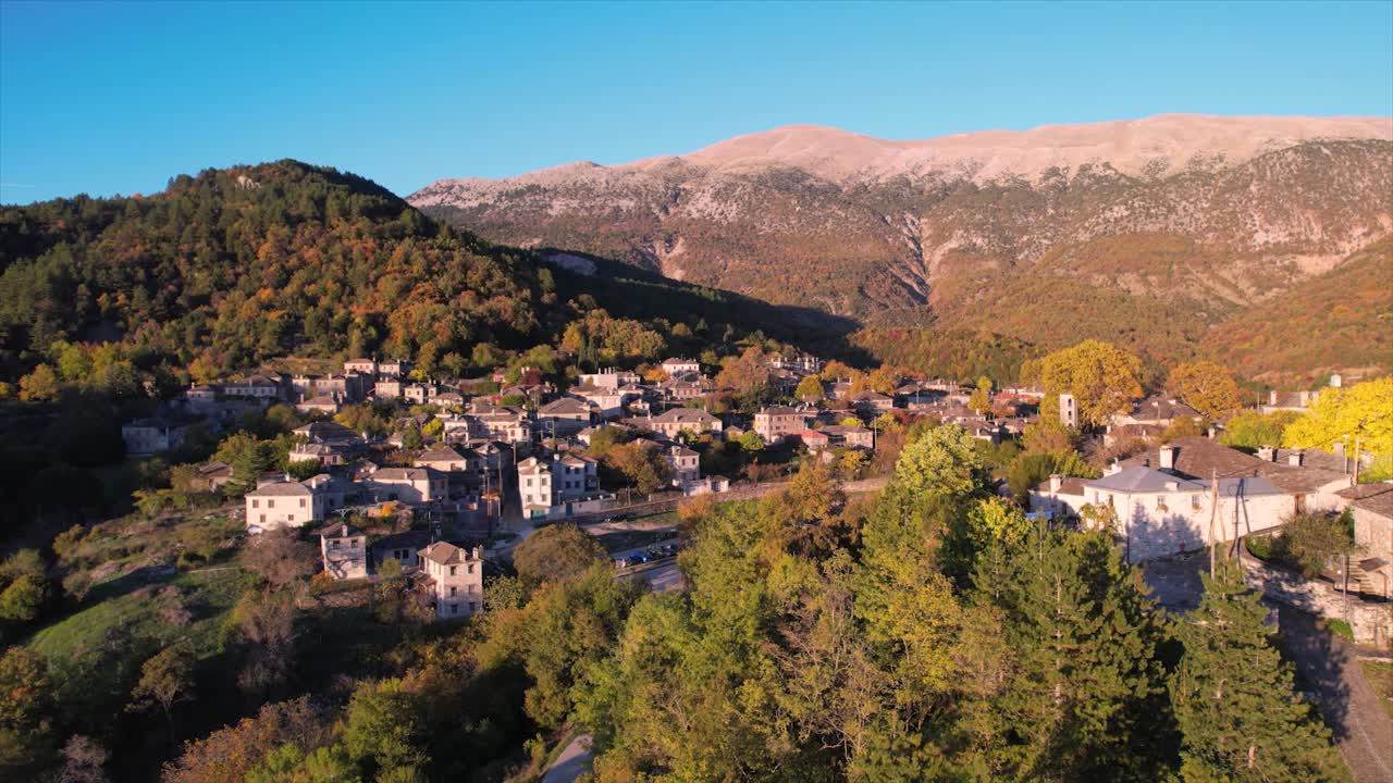 Luftfoto af interessepunkt i Papigo-landsbyen i Zagori, Grækenland. Traditionelle landsbystenhuse dukker frem bag naturen, gylden belysning og efterårsfarver, Epirus-regionen, Grækenland