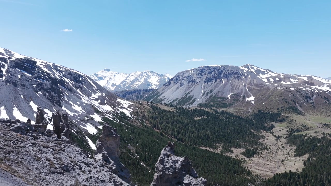Splendida vista aerea della cresta montuosa Il Jalet nelle Alpi svizzere. Cime maestose coperte di neve e una valle verde con una pineta