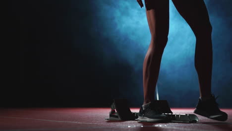 Close-up-legs-of-the-athlete-approach-the-treadmill-and-become-in-position-to-start-the-race