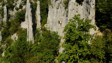 aerial view of active and strong rock climbers climbing at famous vela draga canyon in vranja, croatia