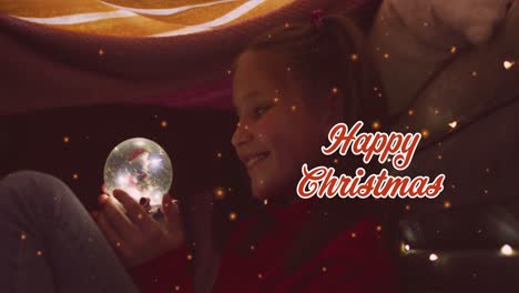 Animation-of-happy-christmas-text-over-caucasian-girl-with-snow-globe