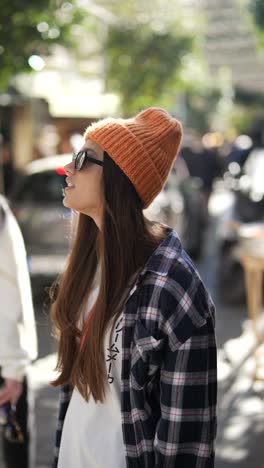 young woman in a plaid shirt and orange hat