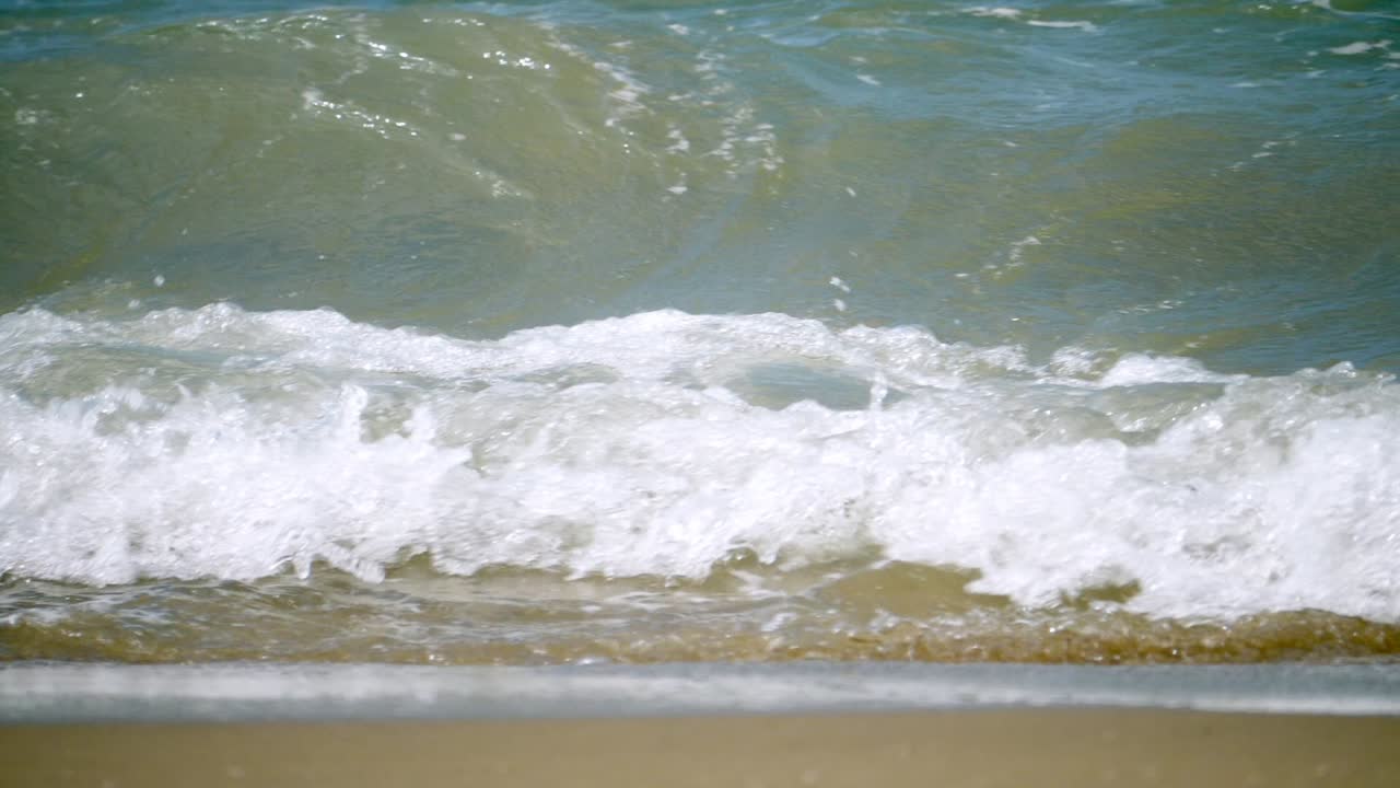 Waves billowing and surging as it pounds the shores of Pattaya Beach in the province of Chonburi in Thailand
