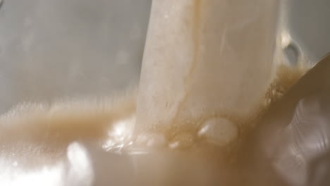 macro shot of soda being poured over ice