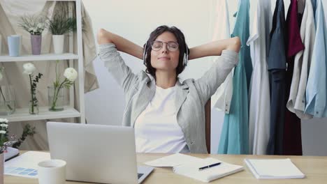 peaceful young businesswoman relaxing, listening to music.