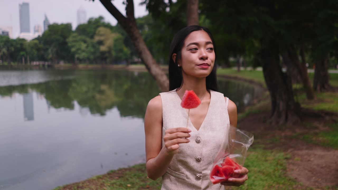 Woman eating watermelon in a park