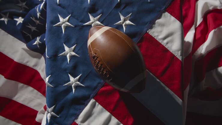 overhead-studioaufnahme des american football auf der flagge der stars and stripes