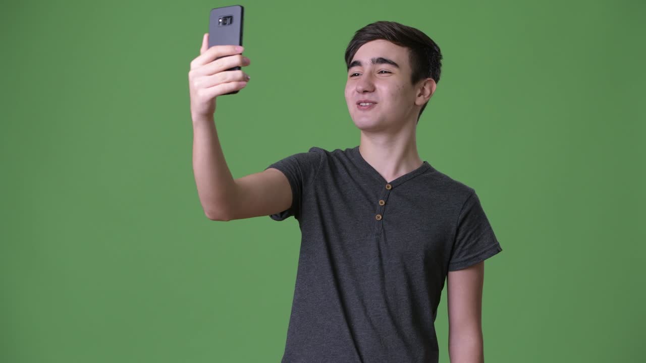 초록색 배경에 젊은 잘생긴 이란 십대 소년