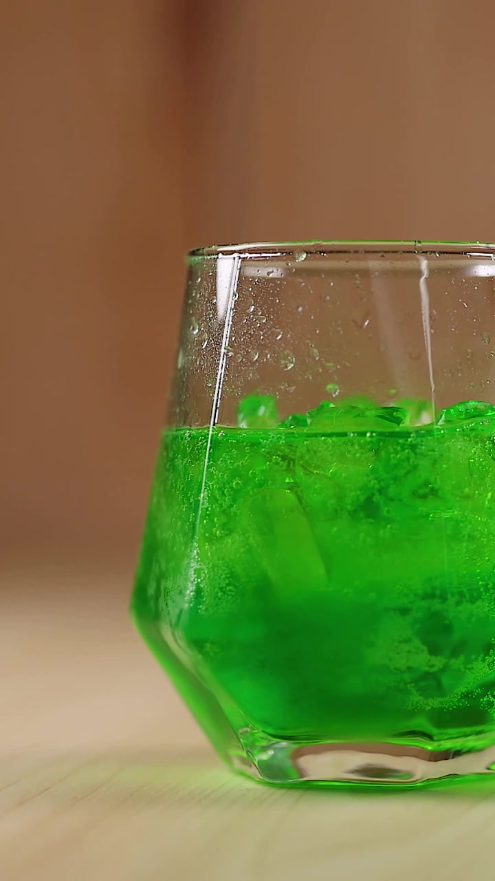Liquido verde con ghiaccio in un bicchiere