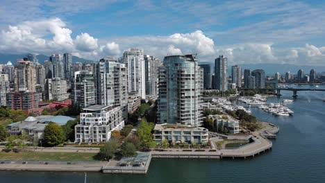 Drone-shot-of-the-Sea-Wall-in-Yaletown-downtown-Vancouver-including-False-Creek,-buildings,-boats,-trees,-bridge-during-summer