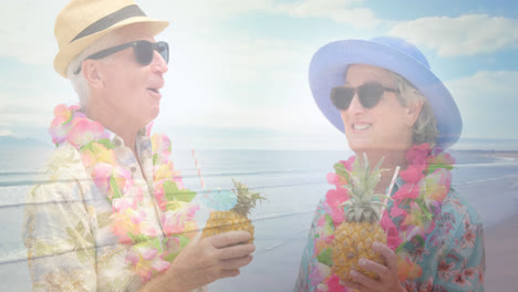 animation of glowing light over happy senior couple having cocktails by seaside