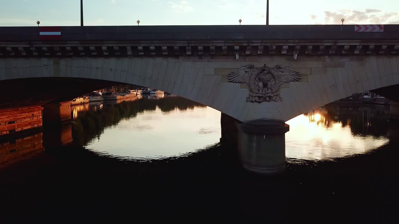 Aerial moving along and facing the Iéna bridge, at sunrise, over seine river. Close