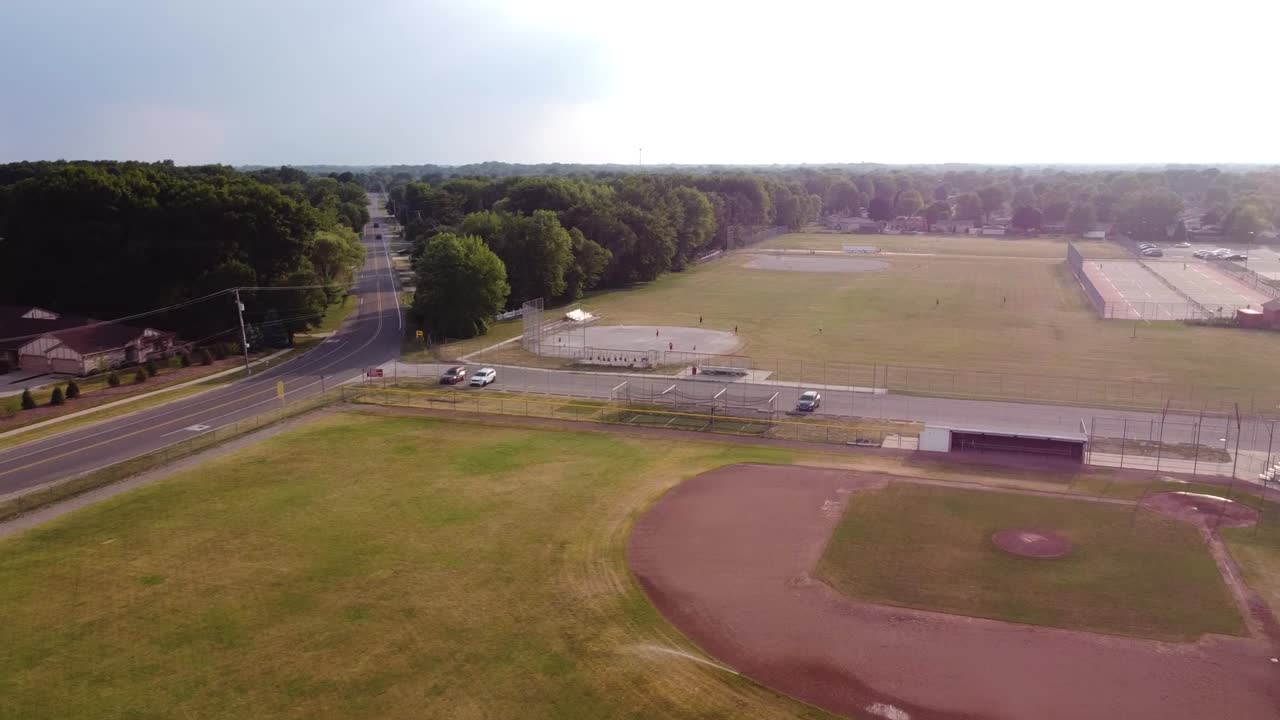 Drone does a quarter spin over a high school baseball diamond.
