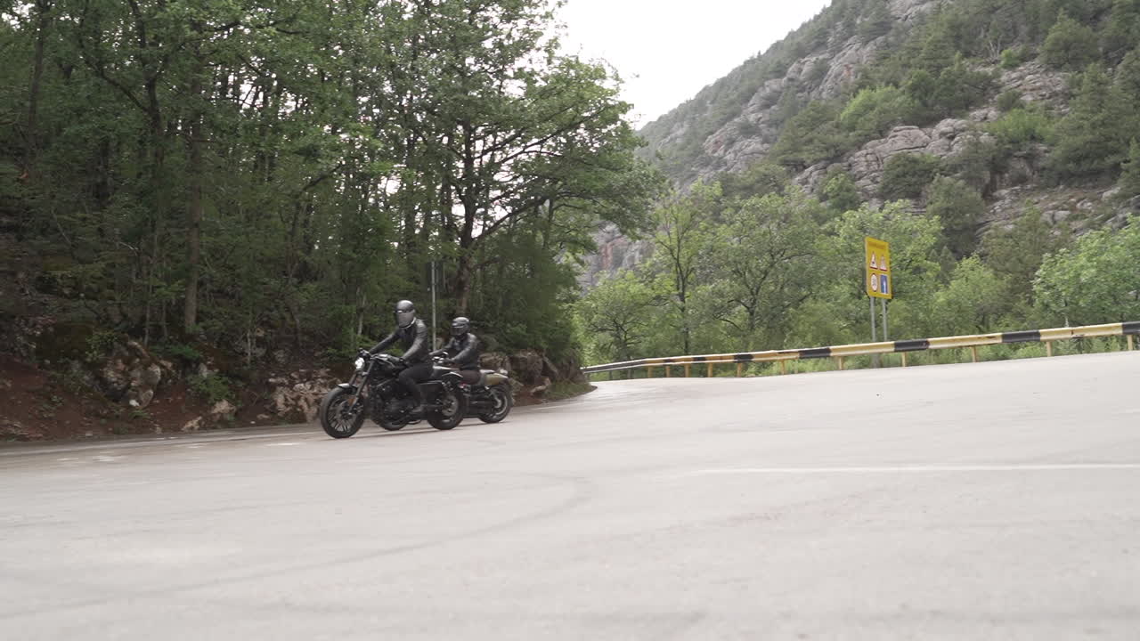 Two motorcyclists on a scenic mountain road
