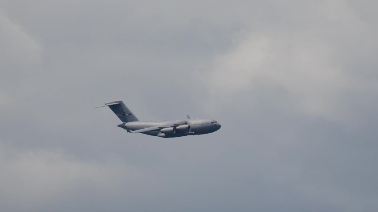 Il C-17 Globemaster esegue una manovra di trasporto merci in un cielo coperto. L'aereo mostra le capacità logistiche militari durante una missione di trasporto truppe.