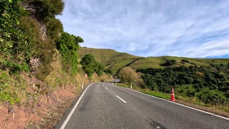 a serene drive along a rural highway in akaroa, showcasing lush greenery and rolling hills under clear skies