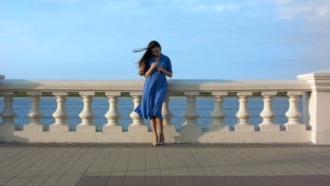 smiling girl in blue dress texting message