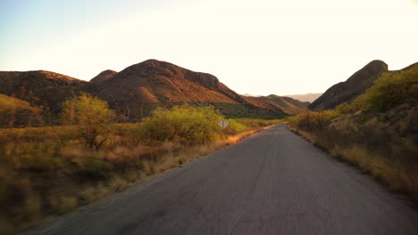 driving on country road through hills in arizona on a sunrise