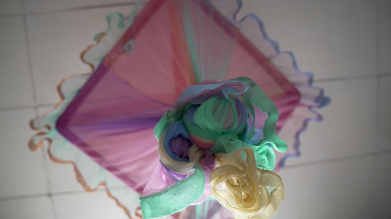 una red de mosquitos de diseño vívido con varios colores unidos al techo, mostrando la utilidad estética y el diseño artístico.