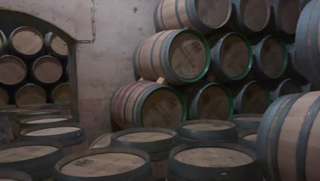 barriles de vino envejecidos apilados en una bodega oscura
