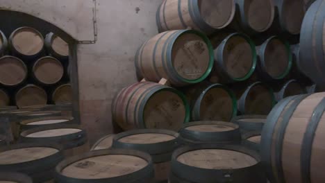 aged wine barrels stacked in dim cellar