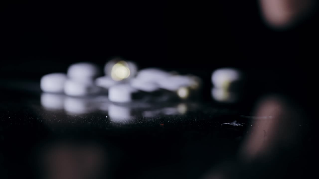 Mano femminile che prende una compressa vitaminica da un tavolo che mostra nutrizione, cura e salute