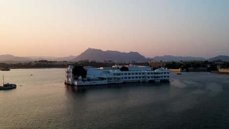 Lago-Pichola,-Toma-Aérea-Al-Atardecer-Del-Palacio-Del-Lago-Taj-En-Udaipur,-Rajasthan,-India