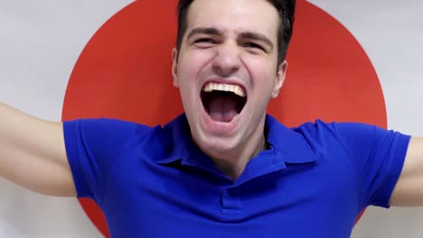 japanese young man celebrates holding the flag of japan in slow motion