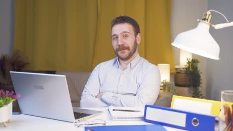 home office worker man smiles at camera.