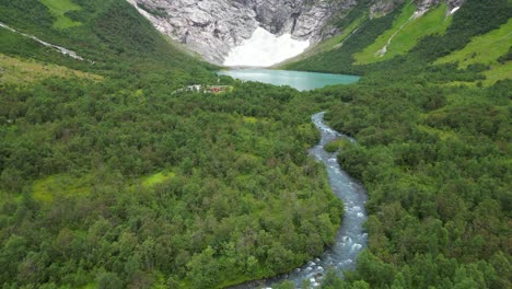 jostedalsbreen glacier norway - boyabreen viewpoint and turquoise blue glacial lake - aerial reveal tilting up