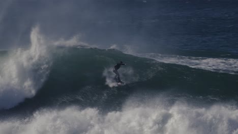 Un-Surfista-Montando-Olas-Enormes-Y-épicas,-Creando-Chorros-De-Espuma-Blanca-Y-Emoción-Que-Bombea-Adrenalina-En-El-Agua