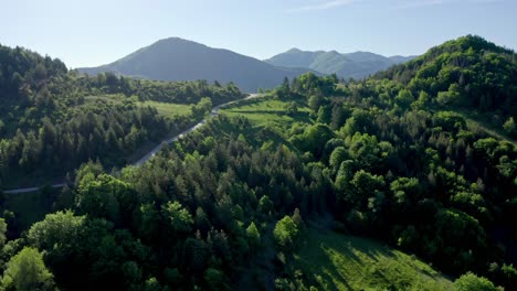 Zipline-drone-shot-of-a-winding-road-leading-to-the-Rhodope-Mountains-in-Bulgaria