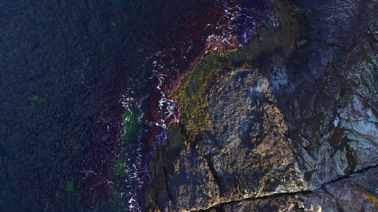 Breathtaking view of rocky coastline with crashing waves at sunrise, showcasing nature's beauty and power