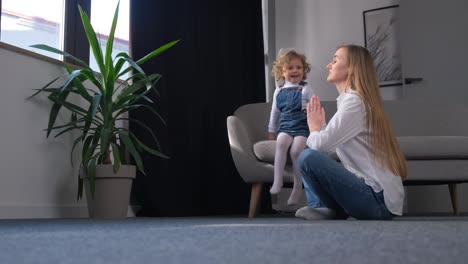 a mother and daughter are playing in the living room