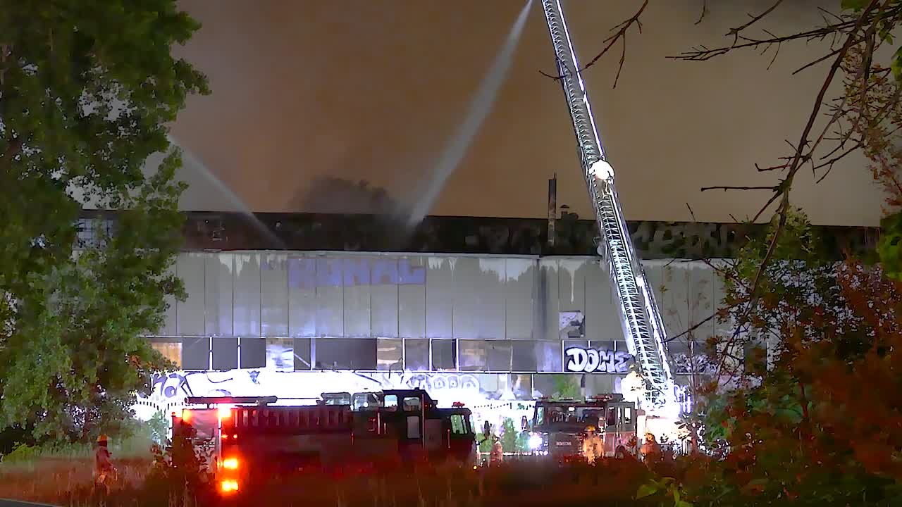 Static shot of additional fire trucks arriving to tackle an apartment blaze
